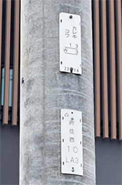 電柱に設置している白いプレートの写真