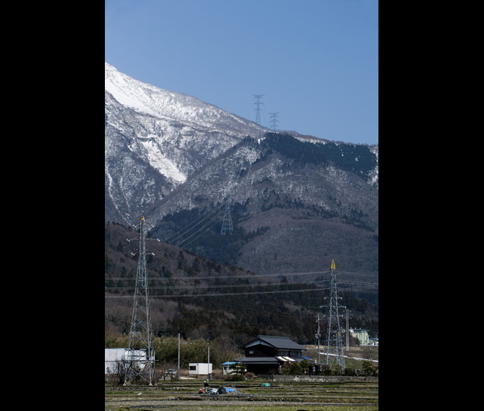 残雪が残る春の伊吹山地と送電鉄塔